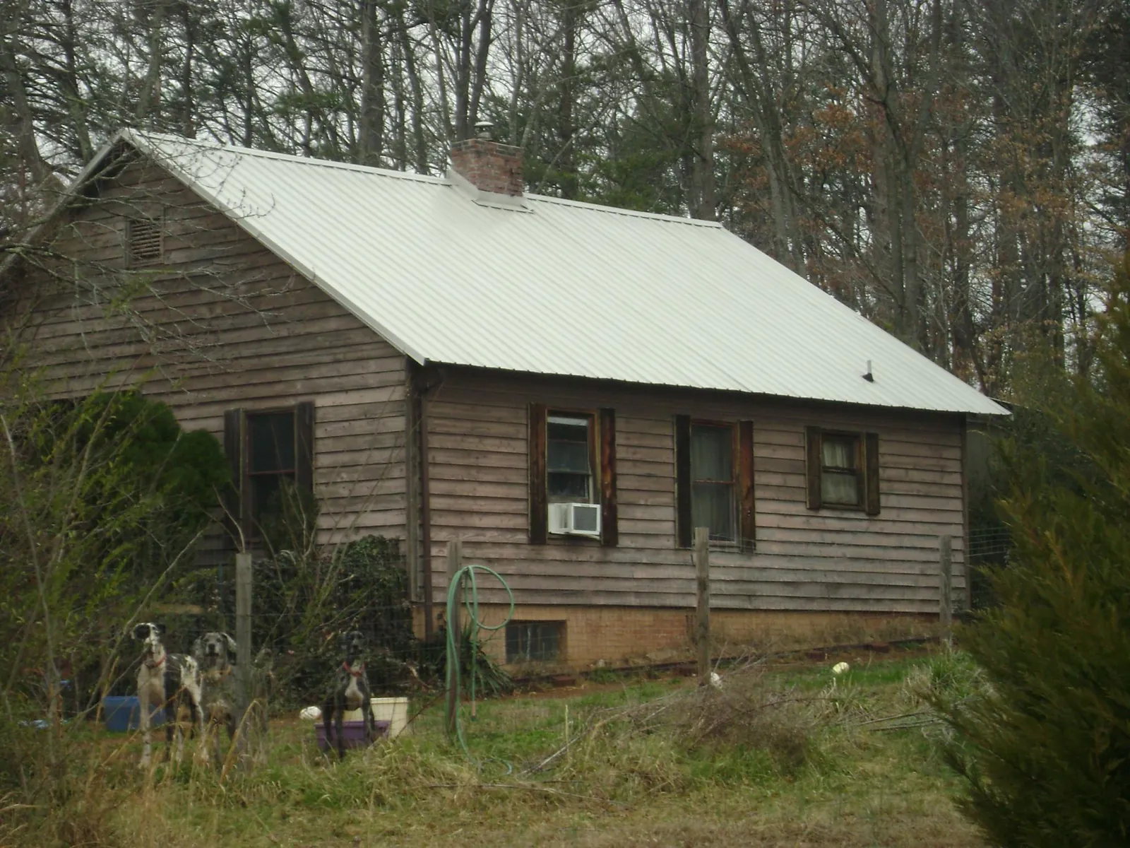 White metal roof on an old wood sided farmhouse, from a Metal Roof Installation job in Jones